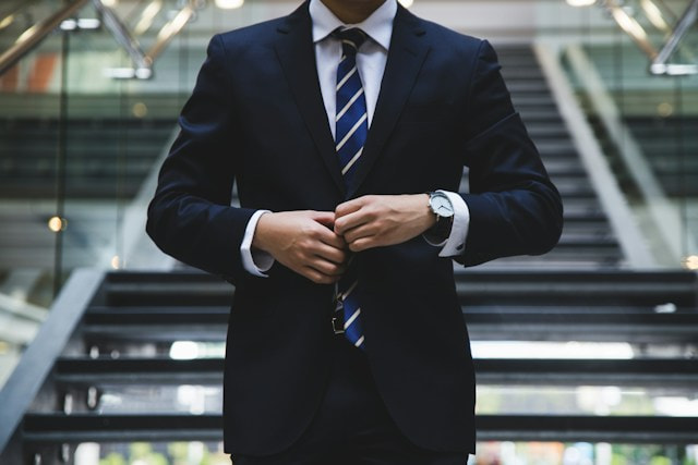 a man in a suit buttoning his jacket